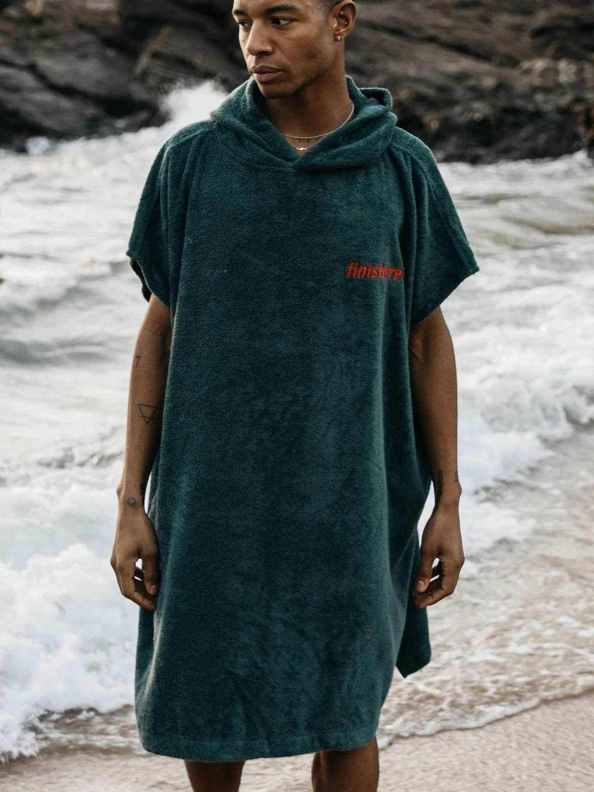 A man wearing an organic cotton changing robe from Finisterre