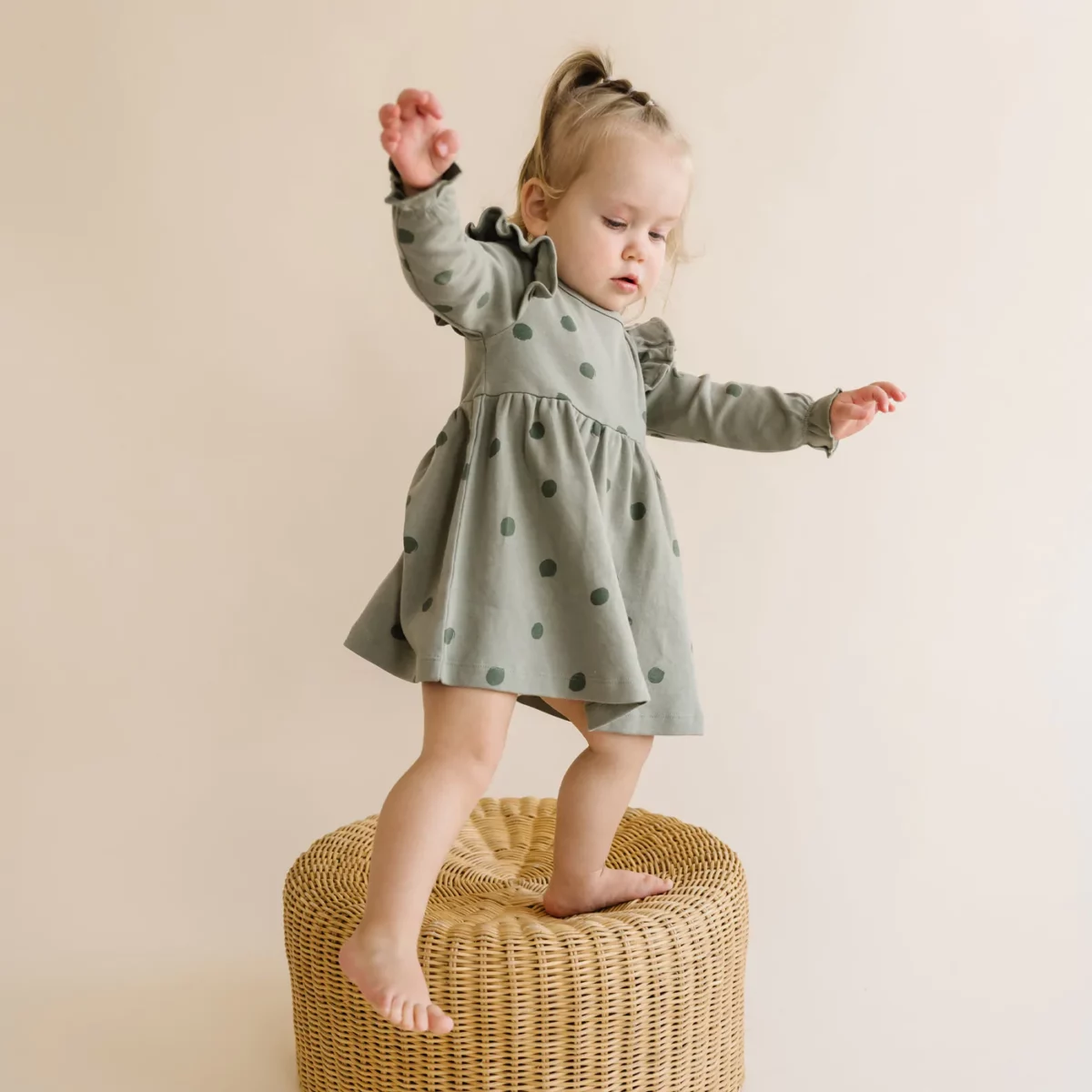 A toddler wearing an organic dress from Make Make Organics.