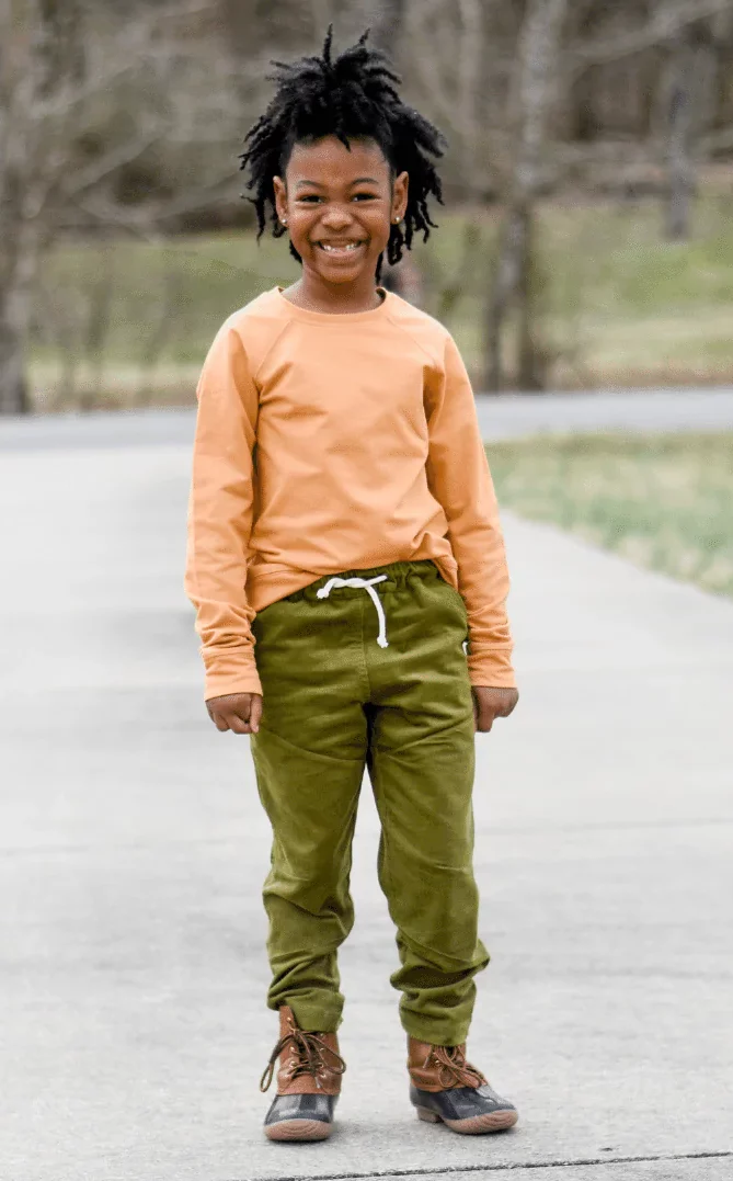 A smiling boy dressed in organic kids' clothes from Jackalo.