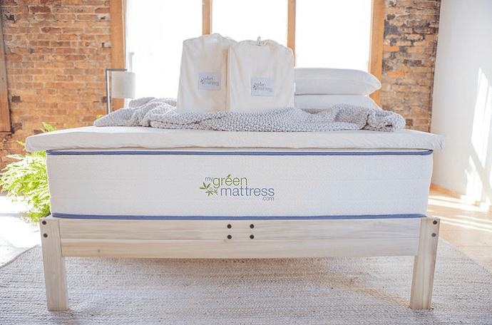 An image of a bed with an organic mattress topper from The Green Mattress