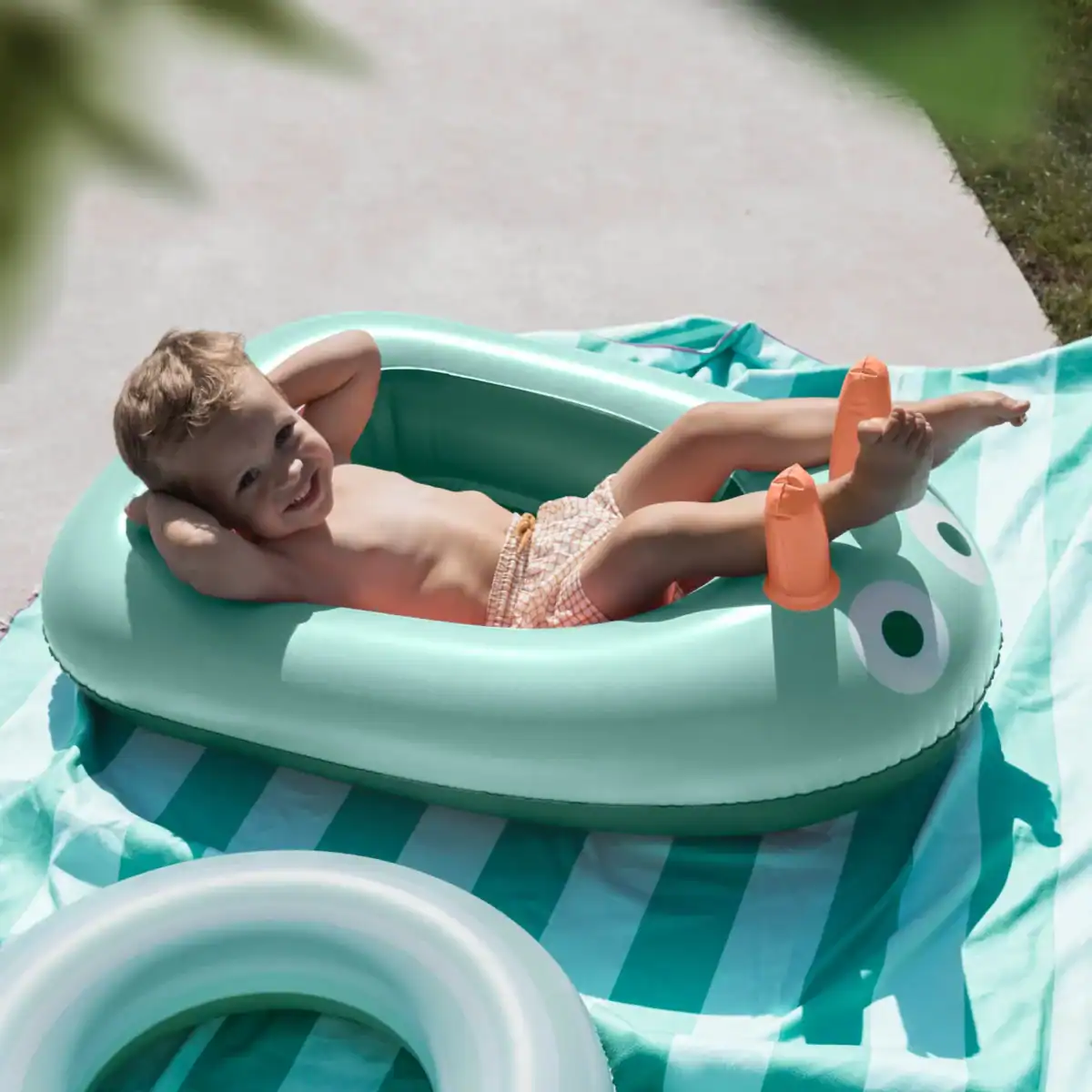 a boy smiling inside a non-toxic inflatable pool for kids