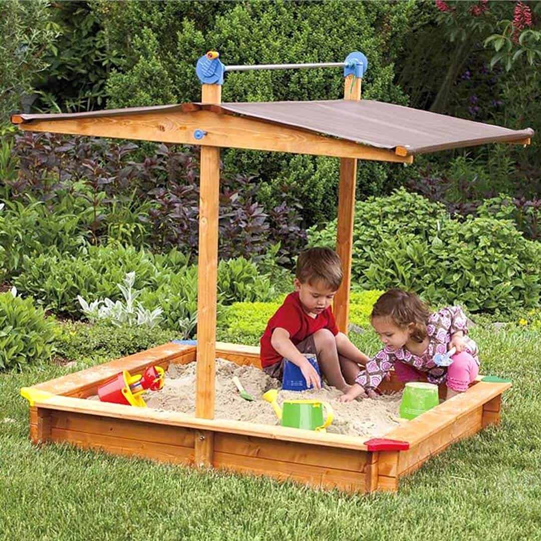 two kids playing non-toxic play sand in a solid wood sandbox from Bella Luna Toys