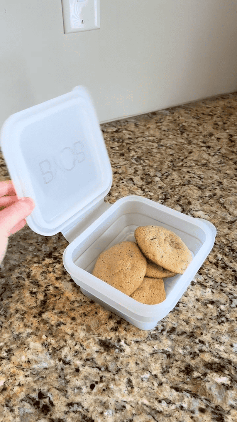 A collapsible silicone box from BYOB, filled with cookies inside.