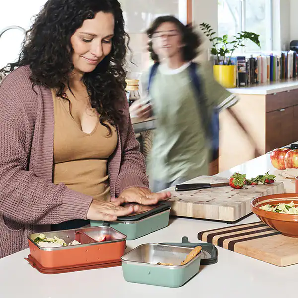 A mother packing her son's lunch with Klean Kanteen bento boxes.