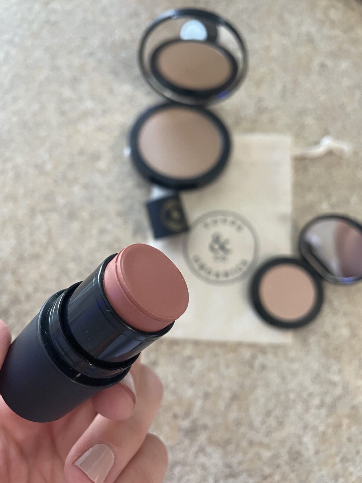 a person holding a cream cheek tint