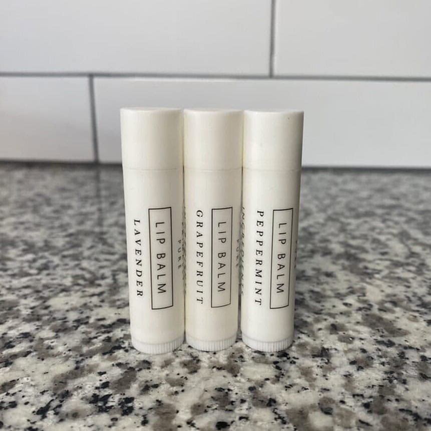 three tubes of Primally Pure's Lip Balm lined up on a countertop
