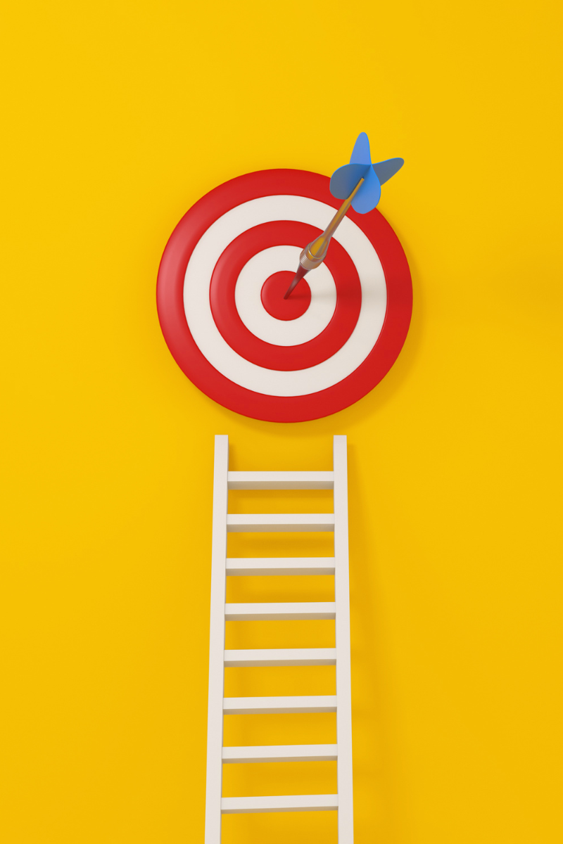 11:53 AMRed and white bullseye target with blue dart in center, white ladder below on yellow background