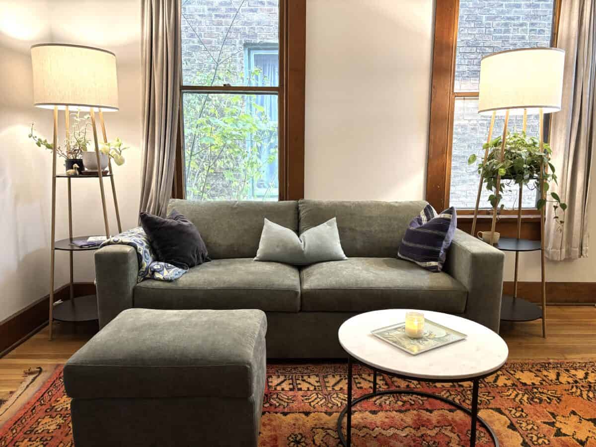 a beautiful Rio Sofa from Medley with lamps on each side and a small circular table with scented candle in front of it