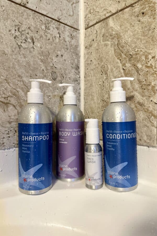 an image of Shampoo, Body wash, conditioner and face wash from Plaine Products inside the bathroom
