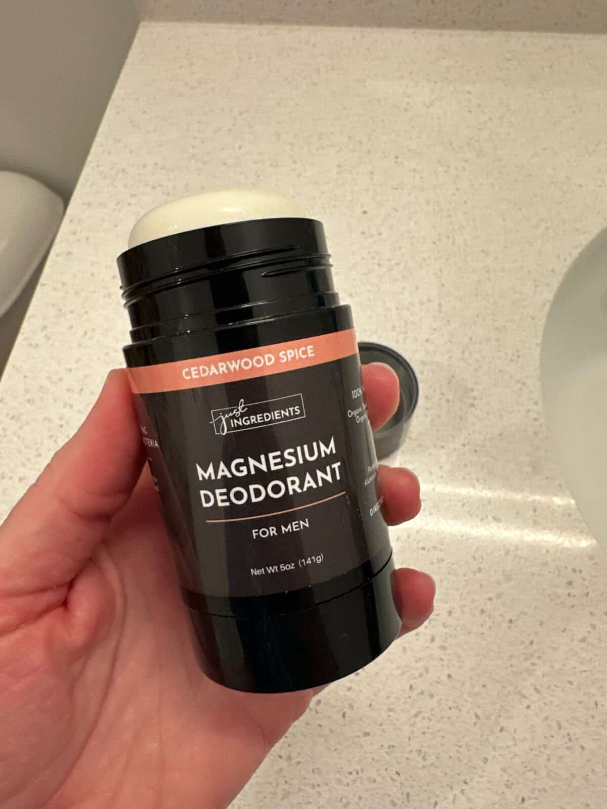 A person showcasing the Magnesium Deodorant for Men in Cedarwood Spice by Just Ingredients