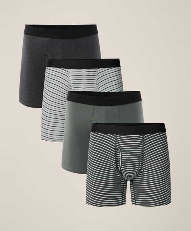 Four pairs of men&rsquo;s boxer briefs in dark gray, sage green, and striped patterns, displayed in a row on a neutral background.