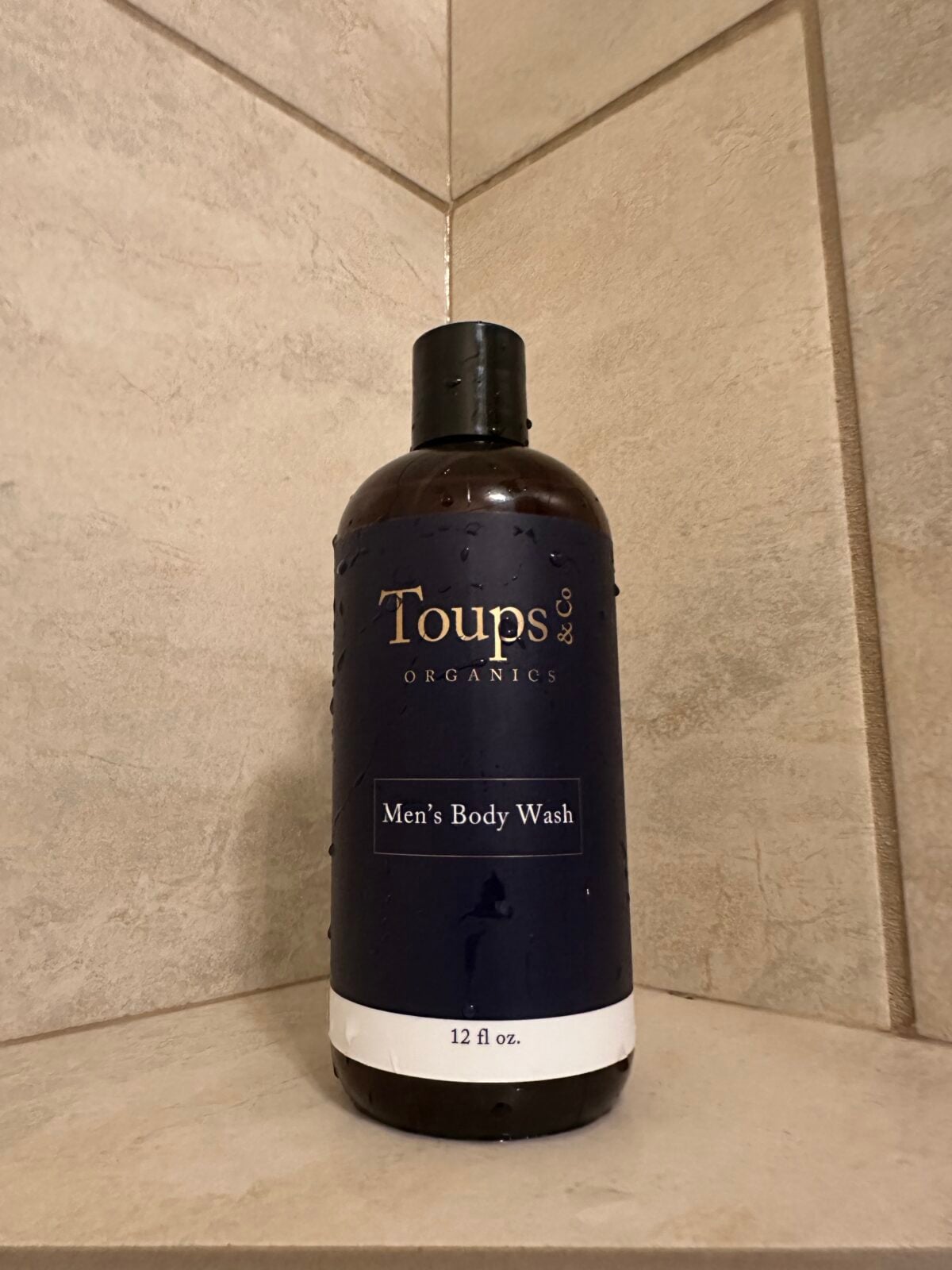 Toups & Co Organics Men&rsquo;s Body Wash bottle on a tiled shower shelf
