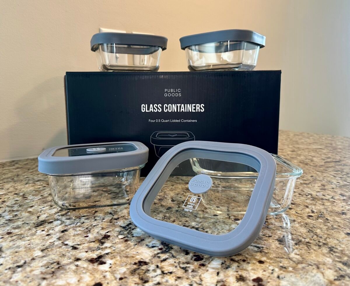 Public Goods glass food storage containers with gray lids displayed on a granite countertop in front of the product box.