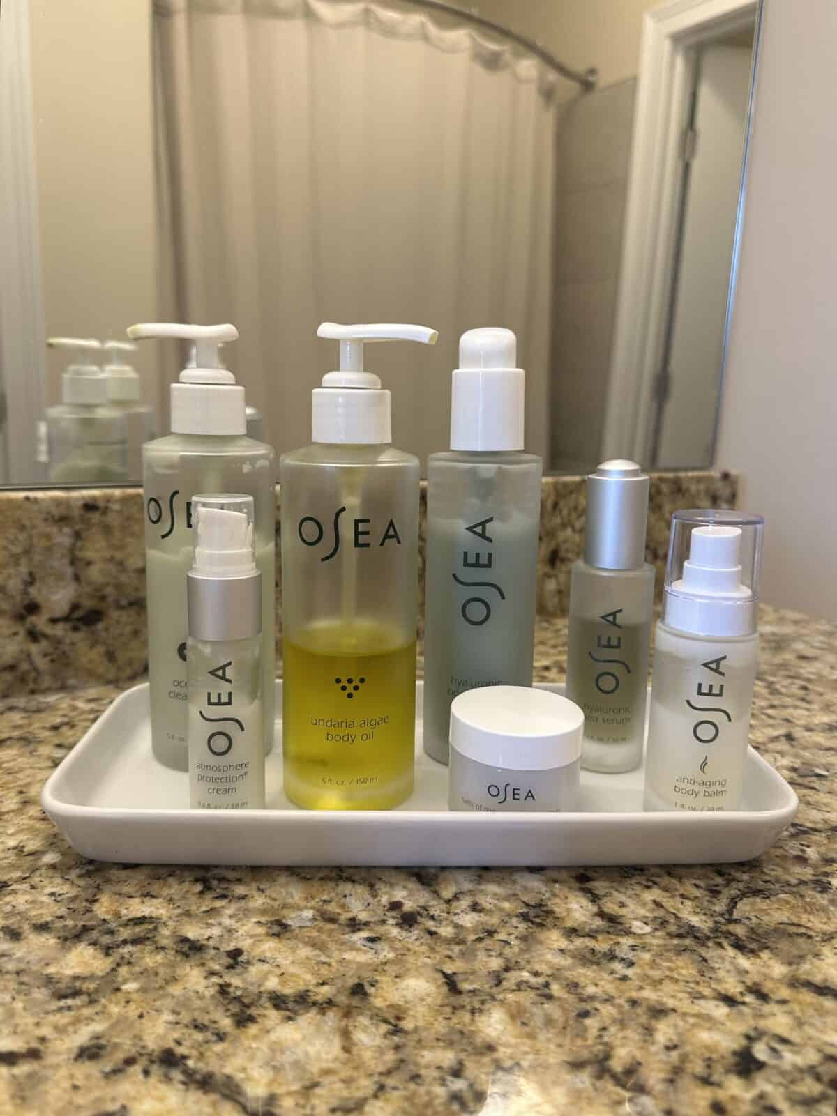 A collection of OSEA travel set products inside the white tray