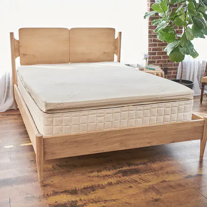 An image of a bed with an organic Adagio latex topper from Naturepedic