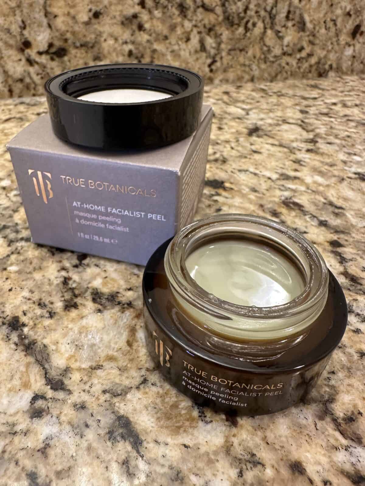 The photo shows the At-Home Facialist Peel from True Botanicals with its box arranged on a granite countertop