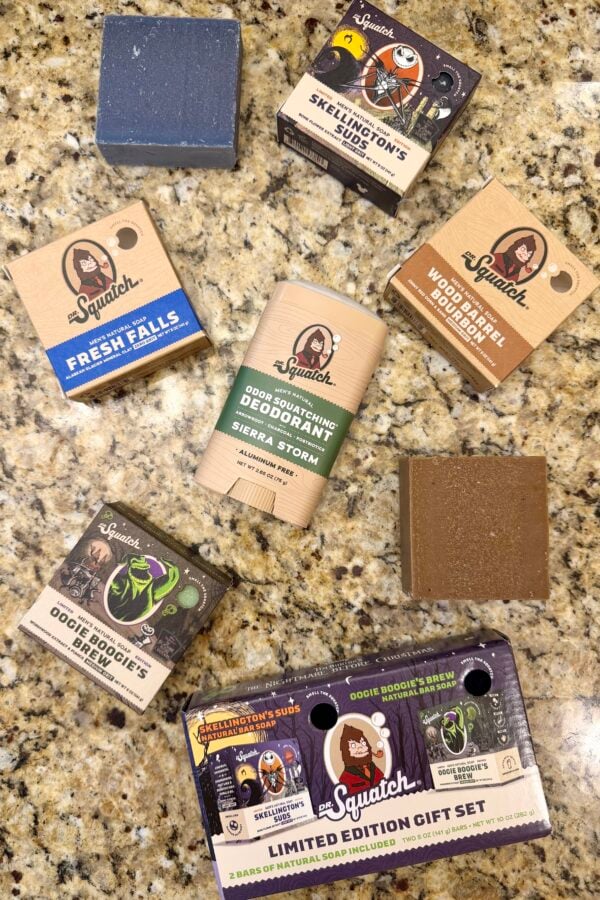 Flat lay of Dr. Squatch men’s soap bars and an aluminum-free deodorant in assorted scents, with boxed packaging and unwrapped bars on a granite countertop.