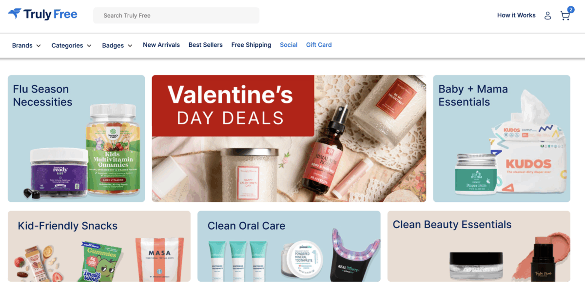 The image displays the Truly Free homepage featuring various shopping sections such as "Flu Season Necessities," "Valentine's Day Deals," "Baby + Mama Essentials," and "Clean Beauty Essentials".
