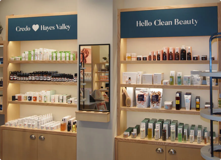 The photo displays the interior of a Credo Beauty store in Hayes Valley, featuring wooden shelves stocked with various "clean beauty" skincare and cosmetic products under blue signage.