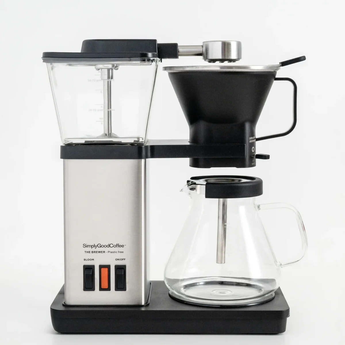 The photo shows a SimplyGoodCoffee brand "The Brewer" coffee machine, featuring a stainless steel body and a glass carafe, designed to be plastic-free.
