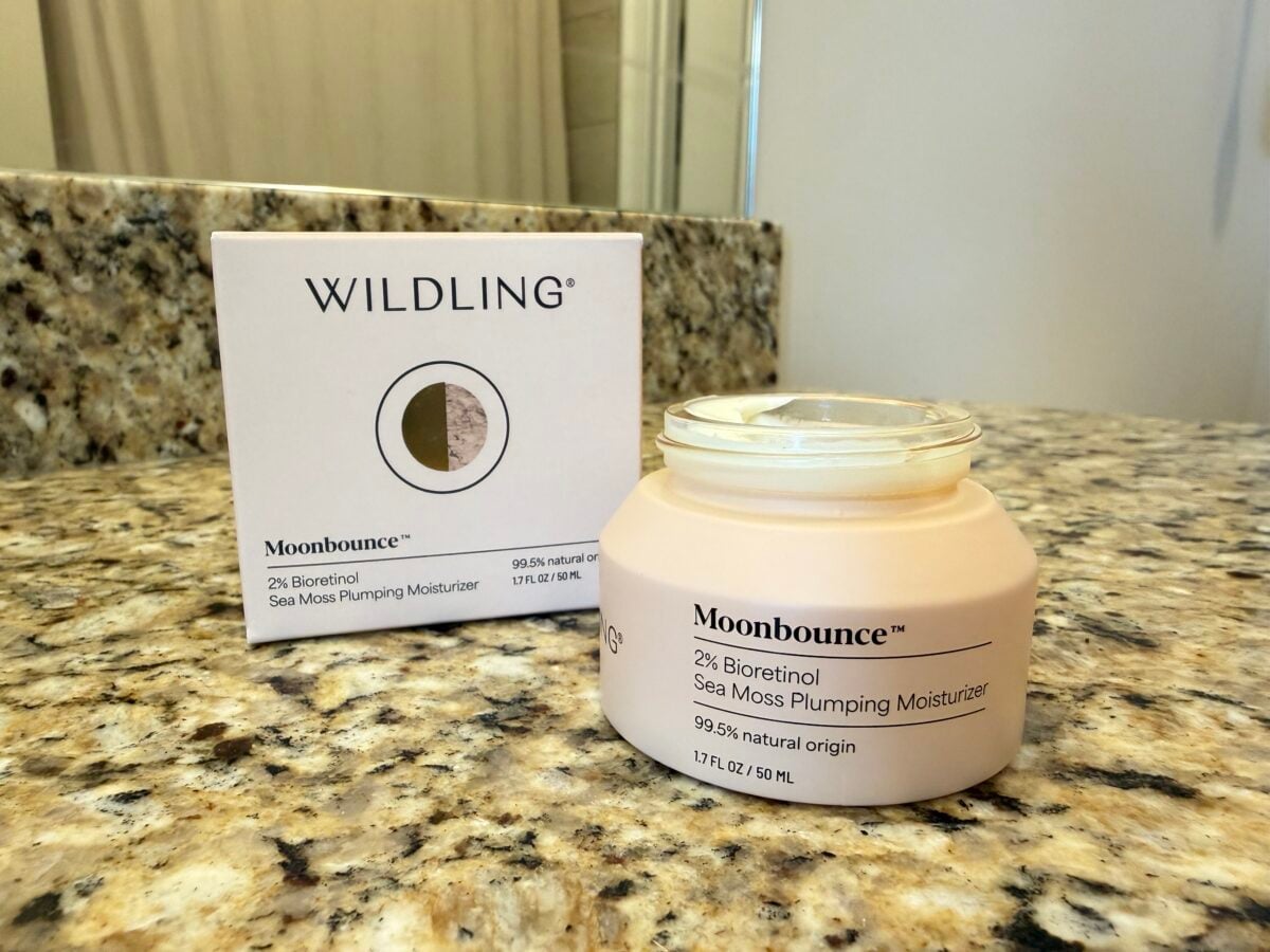 Wildling Moonbounce 2% Bioretinol Sea Moss Plumping Moisturizer open jar and box, 1.7 fl oz, 99.5% natural origin, on granite bathroom counter