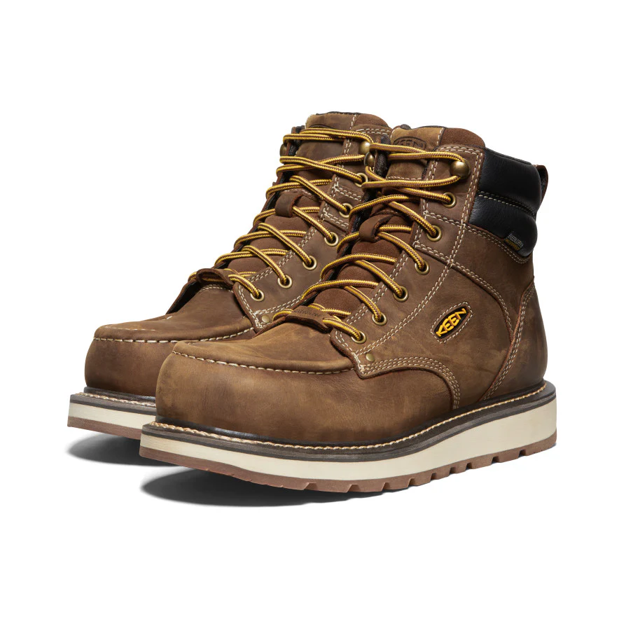 A pair of brown leather work boots with yellow laces, black padded collars, metal eyelets, white midsoles, and rugged brown outsoles, displayed against a white background.