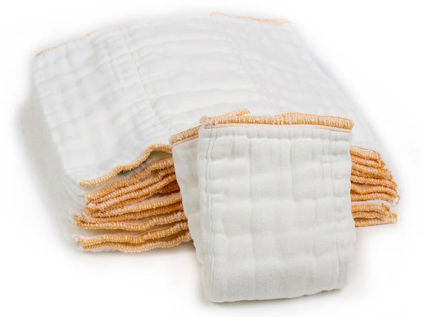 A stack of white rectangular cloth diapers with yellow-orange stitched edges is shown on a white background, with one diaper partly folded and placed in front.