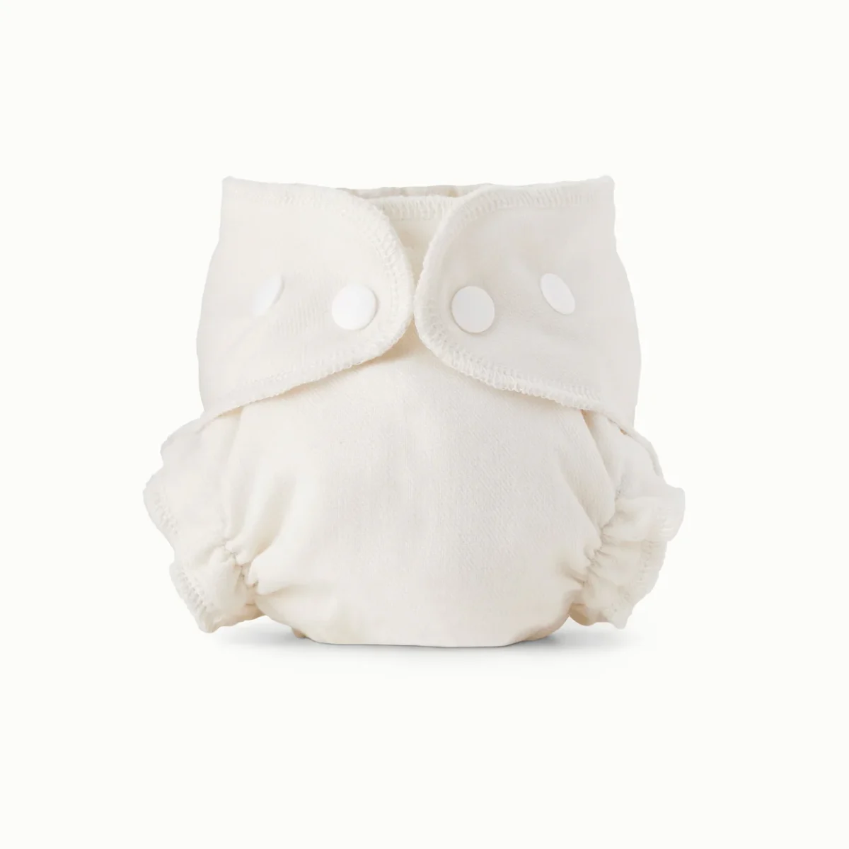 A white reusable cloth diaper with elastic leg openings and three white snaps on the front, displayed upright against a plain light background.