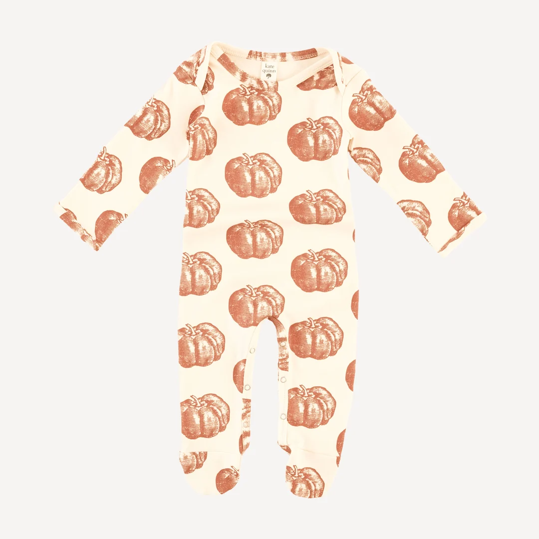 A long-sleeve baby romper with an all-over brown pumpkin print, featuring snap closures along the legs and made of a cream-colored fabric.